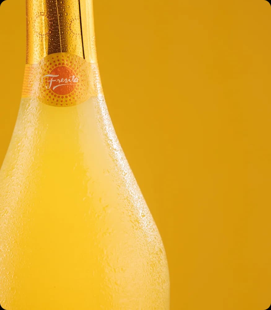 Botella de Fresita sobre fondo rosa con frambuesas