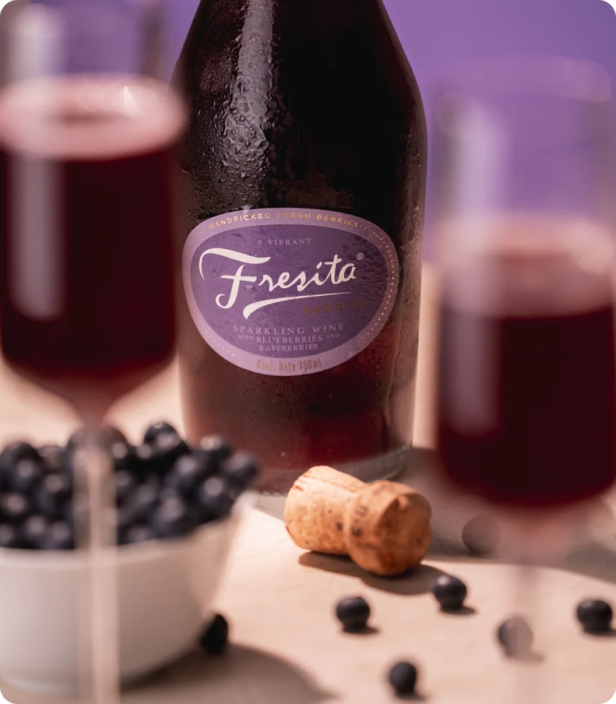 Botella de Fresita amarilla sobre fondo pastel