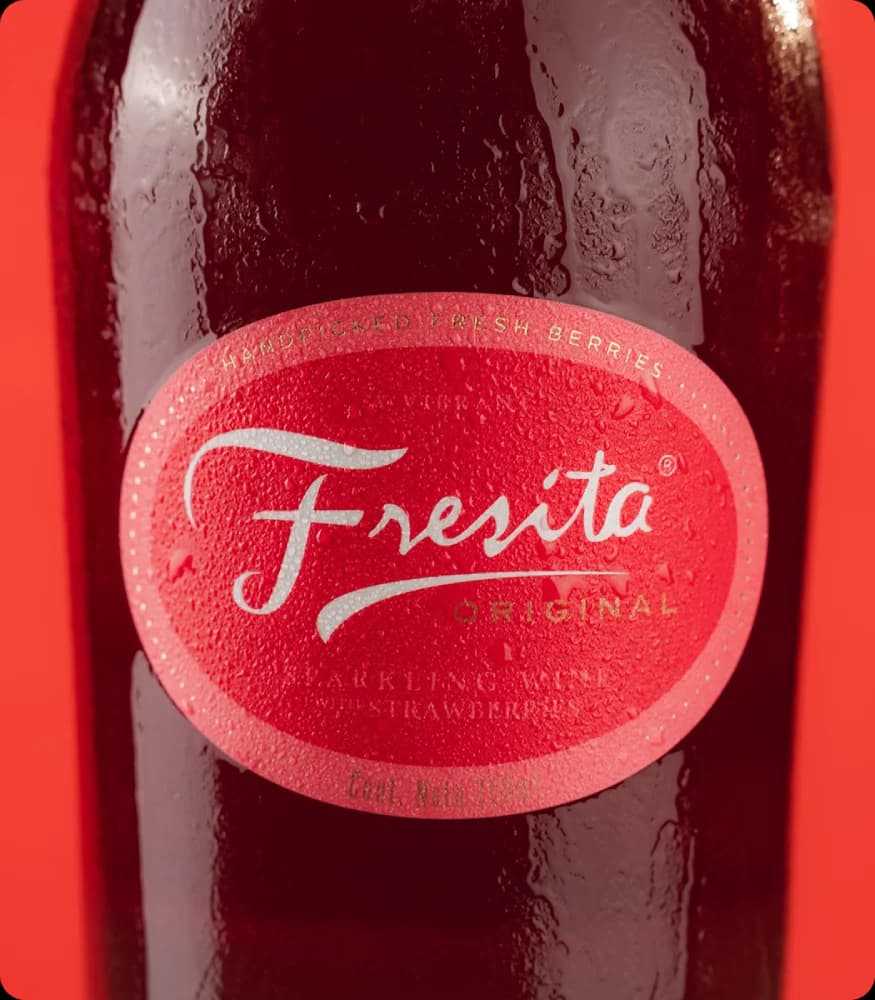 Botella roja de Fresita en fondo cálido