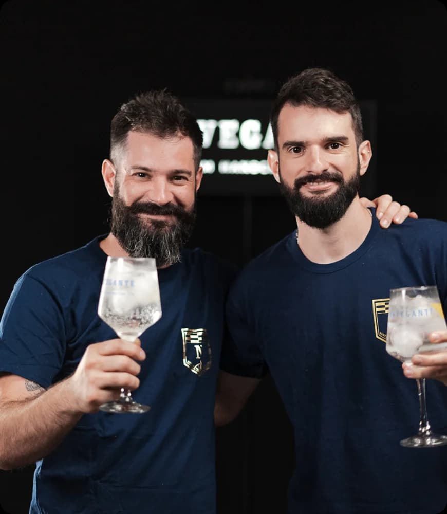 Botella de gin Navegante servida en copa sobre fondo azul
